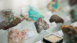 Mineraalinäytteitä vitriinissä Viljo Nissisen mineraalikokoelmassa.