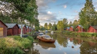 Sundet och båthus på vardera sida om det samt båtar förtöjda vid bryggor.