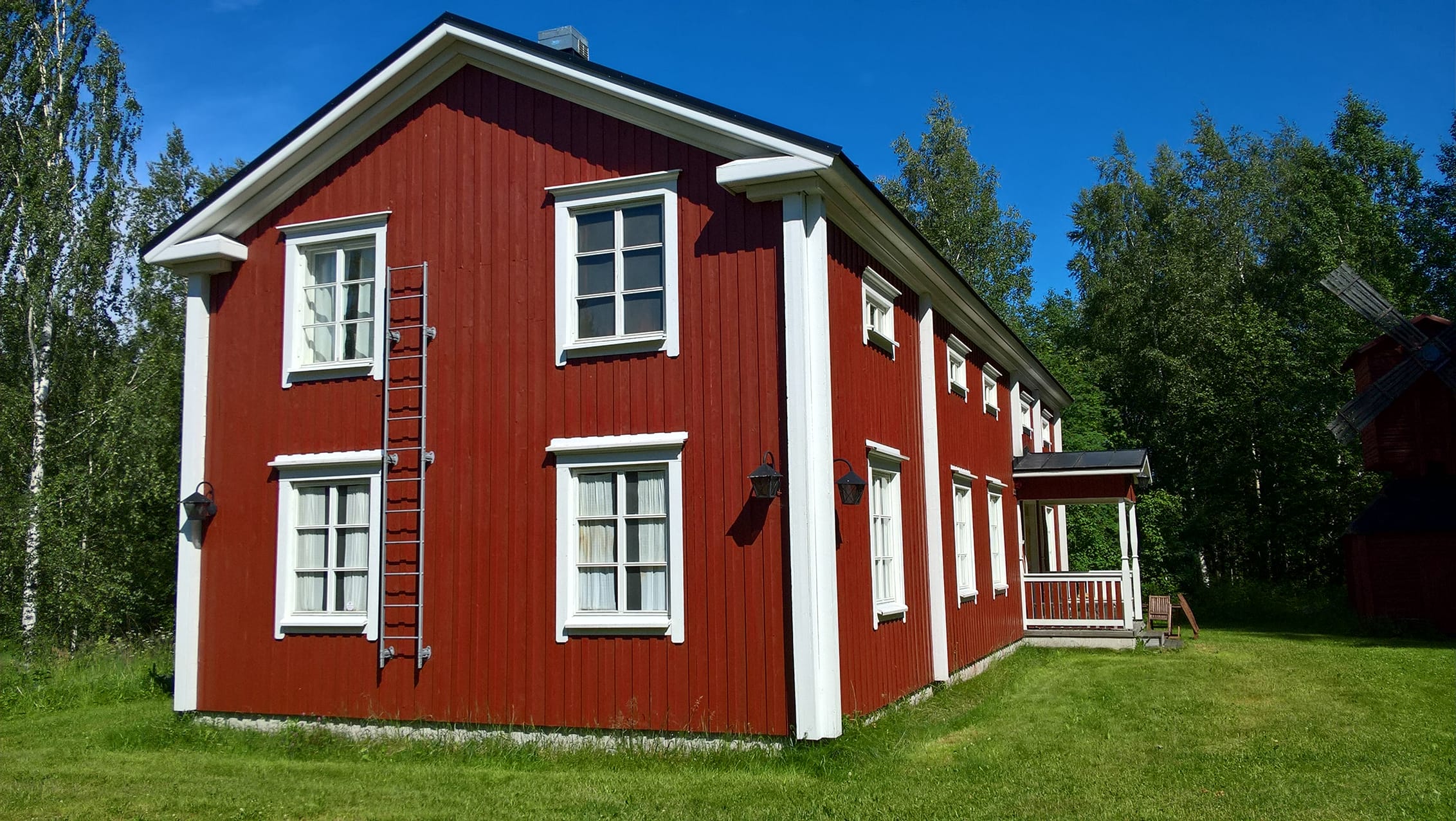 Punainen perinnetalo kesäpäivänä.