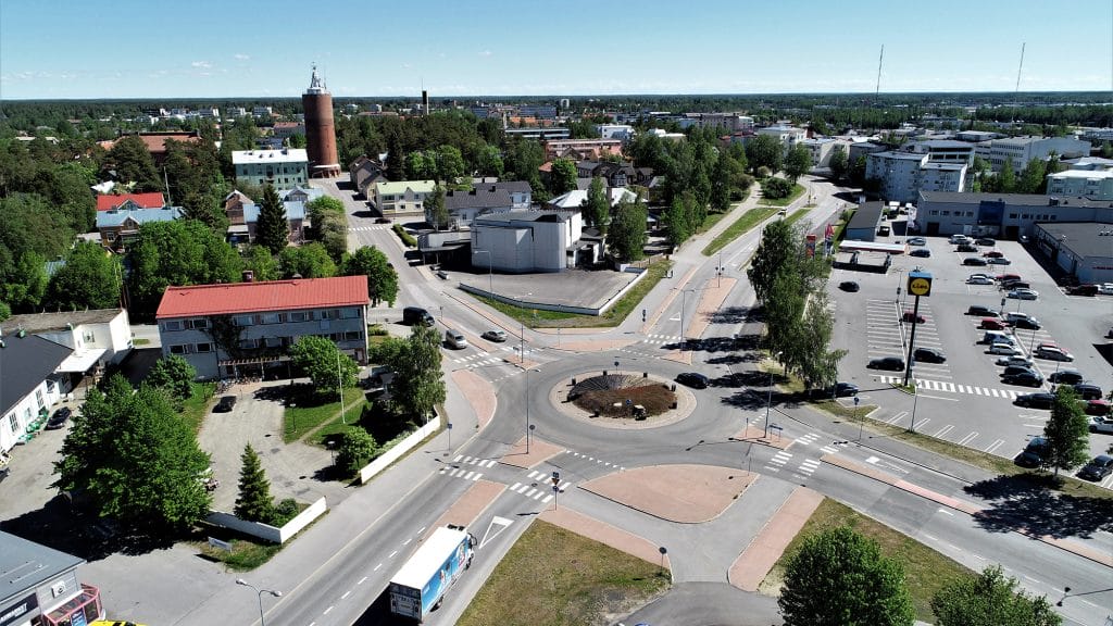 Ilmasta kuvattu näkymä Tehtaankadun liikenneympyrästä ja sen lähialueesta teineen ja rakennuksineen. Hieman kauempana, liikenneympyrästä erkaantuvan Torikadun keskellä seisoo Kokkolan vanha vesitorni.