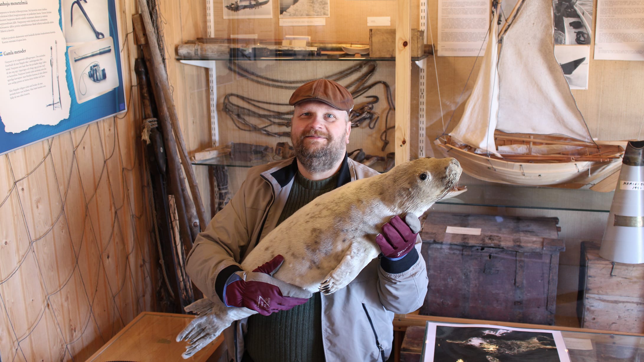 Hymyilevä museomestari pitelee sylissään täytettyä kuuttia.