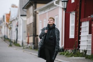 Nuori kävelee katsellen Neristanin värikkäitä taloja.