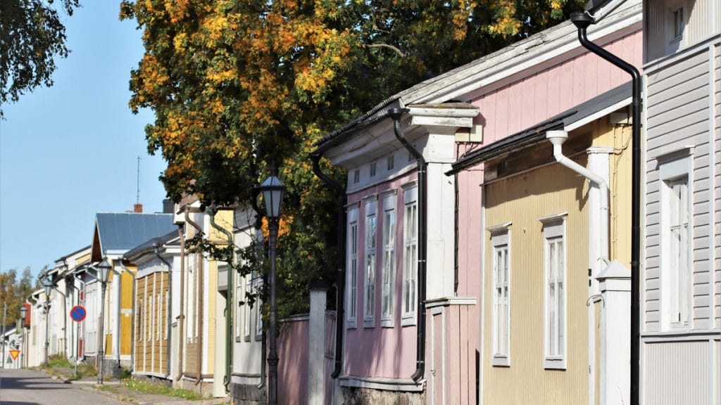 Rivi värikkäitä puutalojen julkisivuja vanhassa kaupungissa