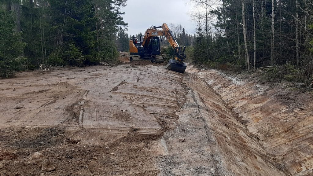 Kaivinkone kaivaa ojaa valmistuvalle tielle