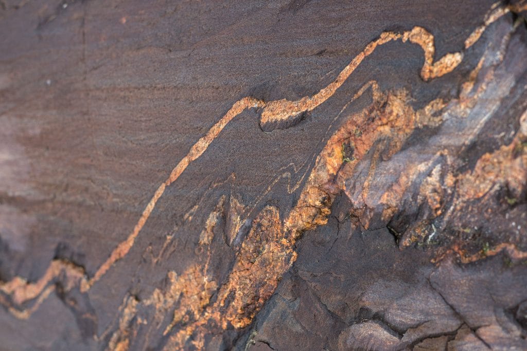 A migmatite is a ”mixed rock” with an older host material and younger partially melted material. Bands or folds of younger material are seen clearly.