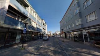 Vy över Storgatan som på båda sidorna har låga våningshus. På våningshusens gatunivå finns affärslokaler och i de övre våningarna bostäder. Gatans mittersta del är av kullerstenar och på båda sidorna om gatan finns parkeringsplatser. I bakgrunden syns Mannerheimplatsen.