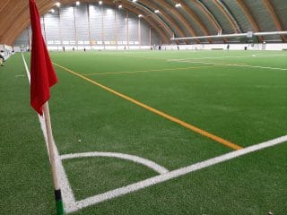 Kuvassa näkyy avara jalkapallohalli, kulmalippu ja kenttämerkinnät