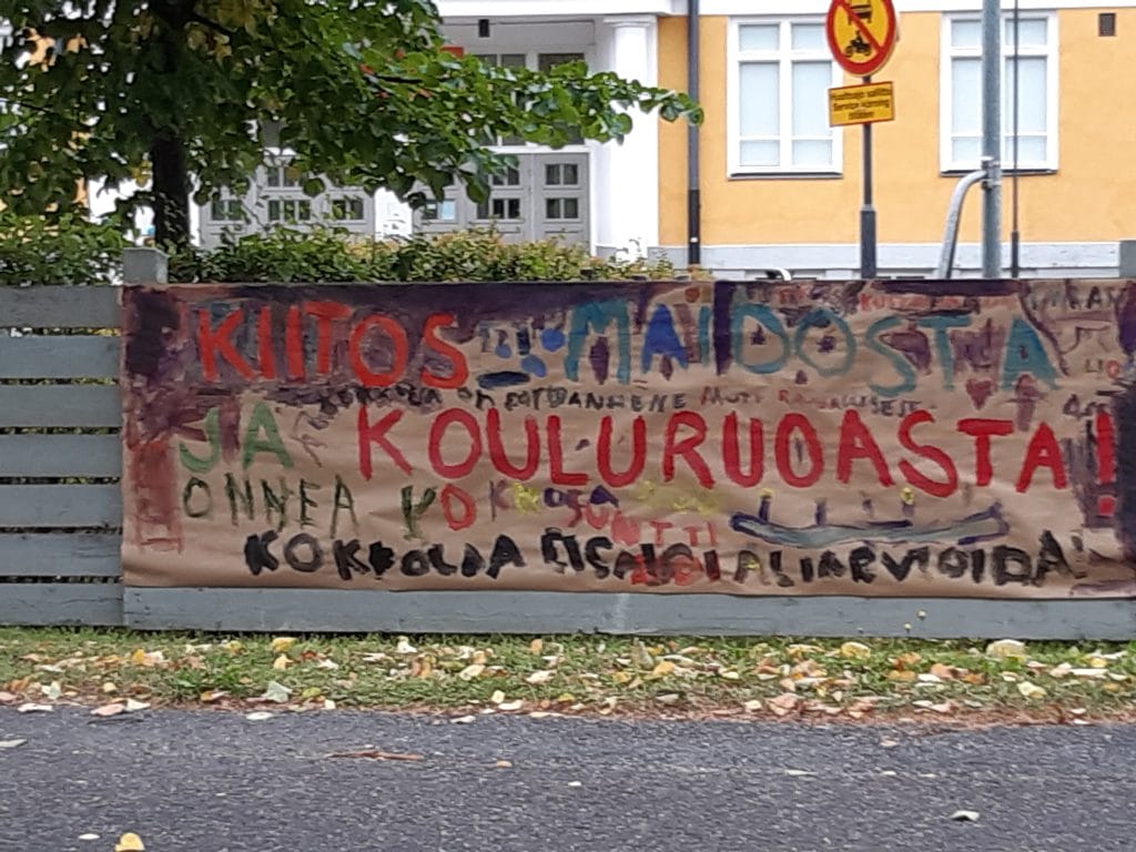 Koulun edessä lasten piirtämä kyltti, jossa lukee kiitos kouluruoasta