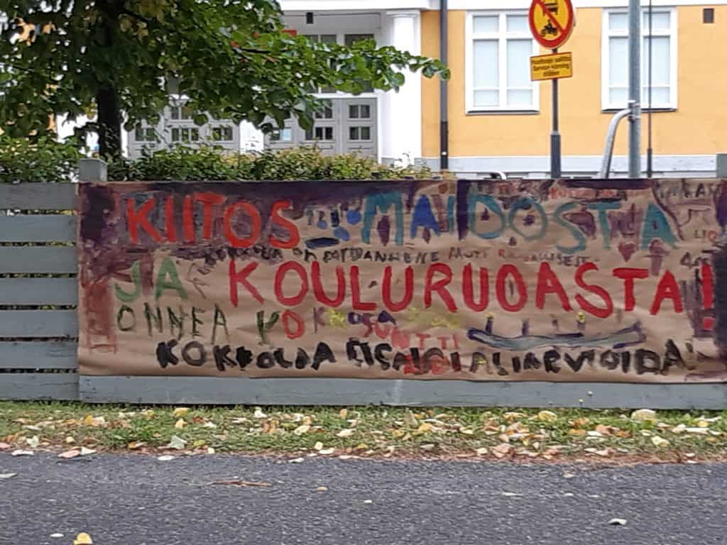 Framför skolan ett skylt, där det står ”tack för skolmaten”