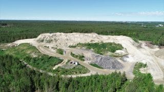 Storkohmos jordtipp fotad högt uppifrån. Runt jordtippen finns ett stort skogsområde.