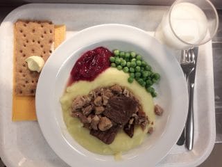 På brickan; matportionen, knäckebröd och mjölkglas.