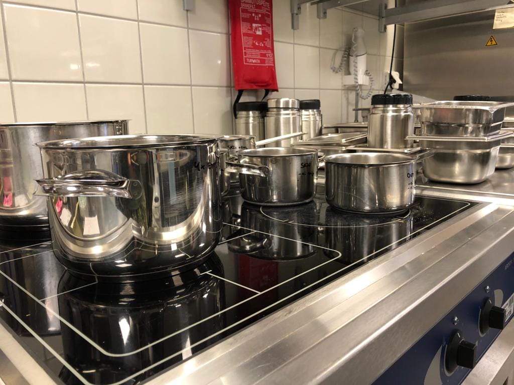 Hellan päällä on paljon kattiloita ja ruokapakkeja.
