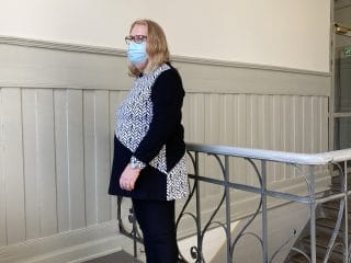 Nainen esittelee trikoopaitaa, jossa mustavalkoinen kuosi tehostekuviona.