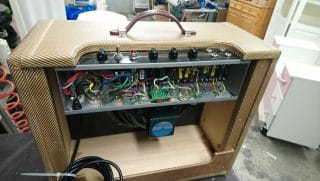 Sähkökitaran kaiutin; takaa avattu, elektroniikka näkyvillä.