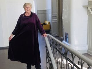Nainen yllään violetti samettimekko.