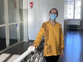 Nainen keltaisessa, trikoopaloista ommellussa tunikassa.