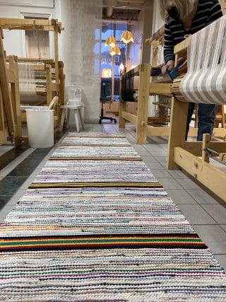 Räsymatto, jossa välissä tehosteraitoina musta, punainen, keltainen ja petrooli.