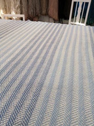 Sinisävyinen raitainen peitto.