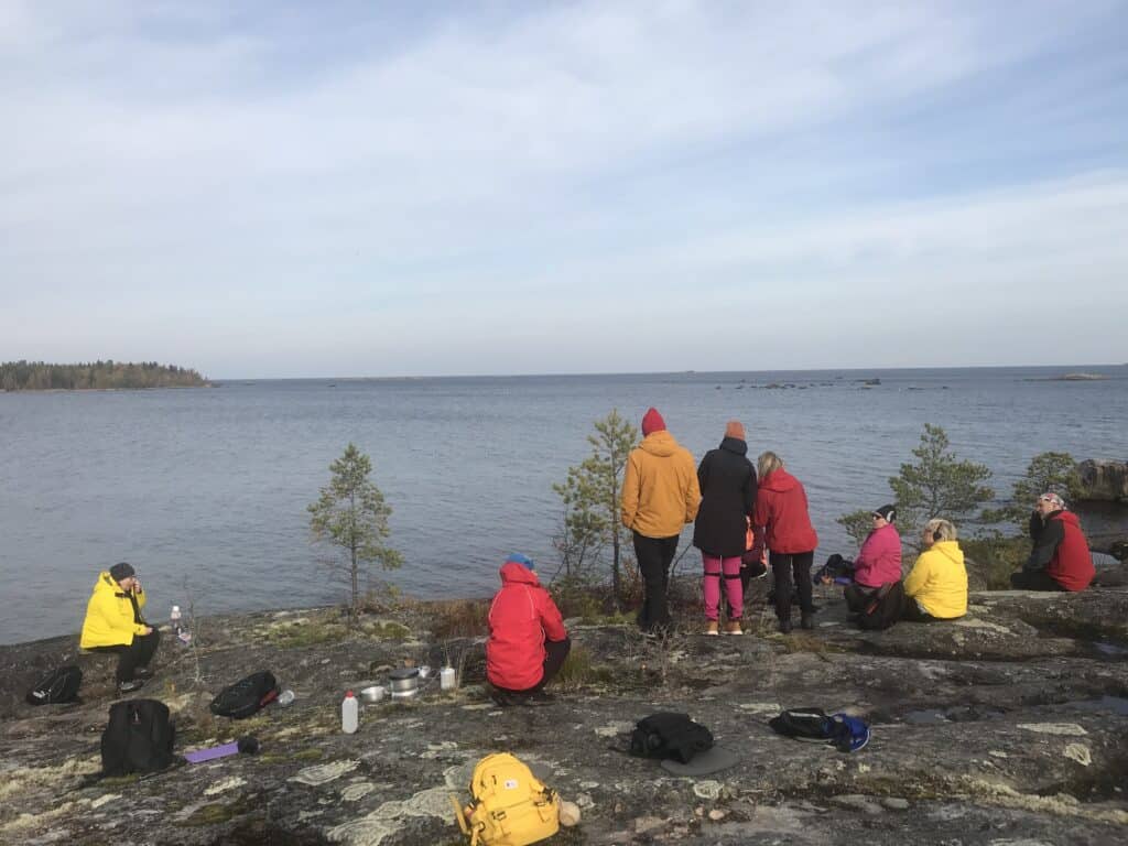 Ihmisiä merenrannalla.