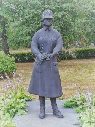 Pekka Jylhä: Lotta. Seisovalla lotalla kädessään ruusu