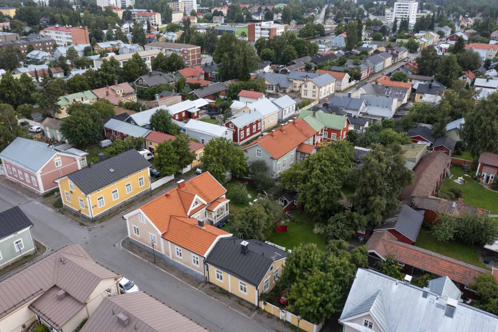 Kokkolan keskustan yllä otettu ilmakuva, jossa näkyy ruutuasemakaavan muotoon rakennettu vanha kaupunki Neristan, ja siellä olevia värikkäitä puutaloja vehreine pihoineen. Taaempana näkyy myös kerrostaloja.