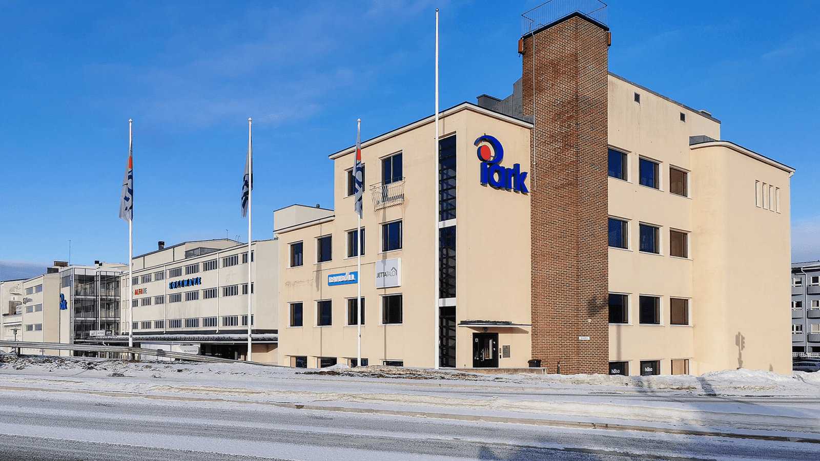 Katu ja kadun takana iso, vaalea rakennus. Rakennuksen seinässä lukee iPark.