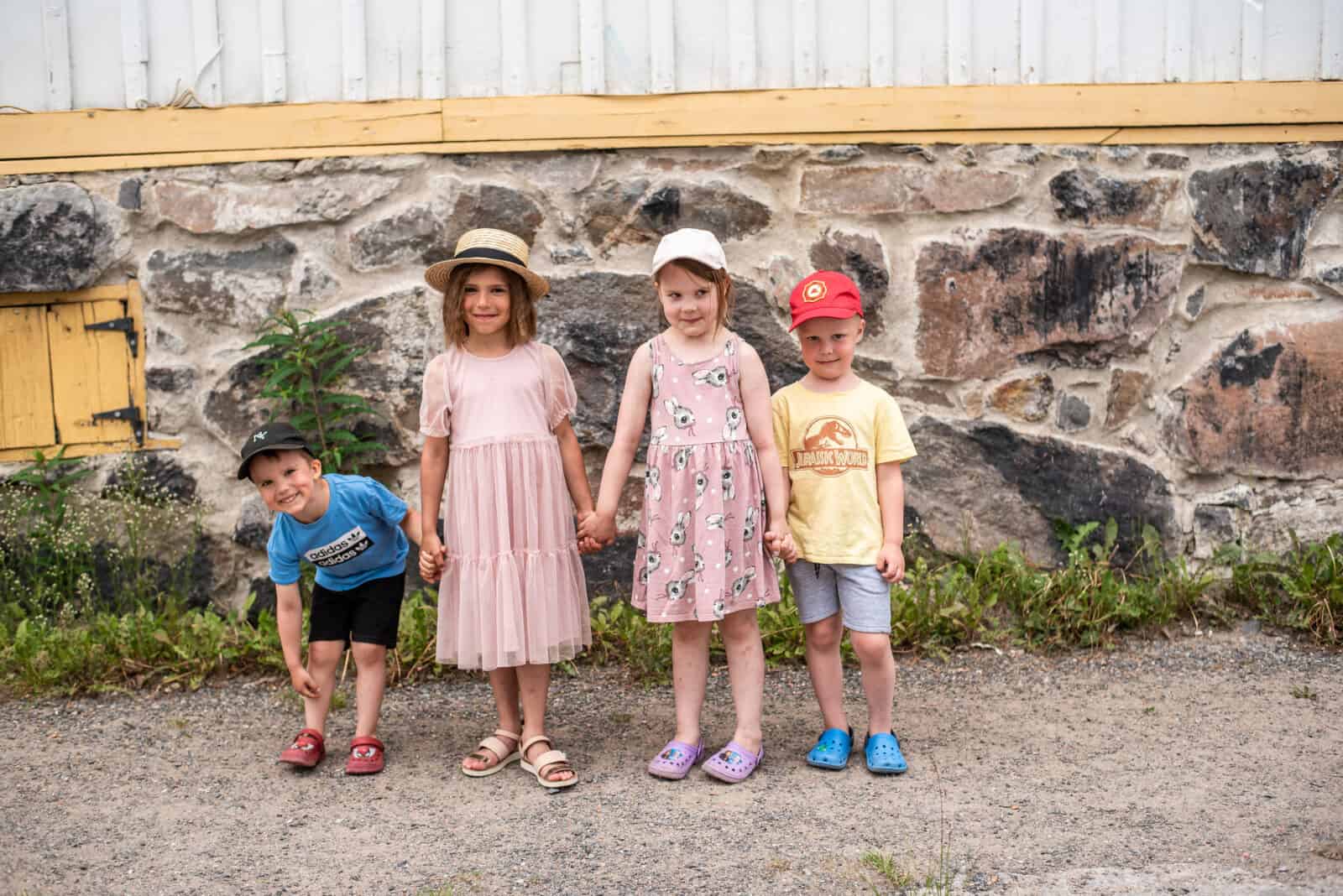 Neljä lasta seisoo Neristanin kadulla ja pitää kädestä toisiaan kiinni