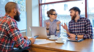 A woman and two men have a meeting.