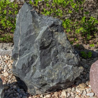 Kiepin kivilajinäyttelyn mustahko näytelohkare.