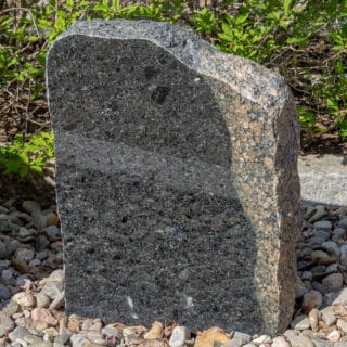 Provblock med mörka och rödaktiga stenarter. Kieppis bergartutställning.