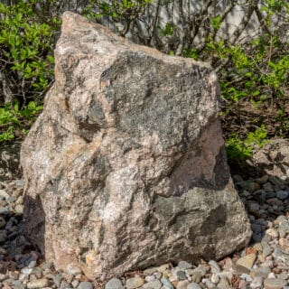 Provblock med rödaktigt och brunaktigt mineral. Kieppis bergartutställning.