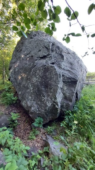 Harmaa suuri kivi polun varrella.