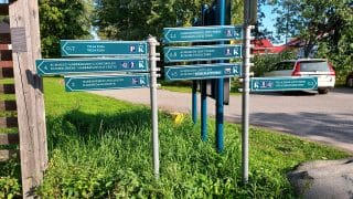  I början av stigen finns skyltar på två skilda stolpar. Skyltarna visar vägen till naturstigar och fågeltorn.