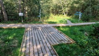 Polku haarautuu neljään suuntaan. Risteyksessä on viittaopasteet ja levennys.