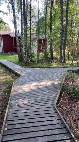 Polku haarautuu. Oikealla reitti jatkuu kohti tulosuuntaa takaisin parkkipaikan suuntaan. Suoraan kuljettaessa parkkipaikalle kuljetaan Majoitusrakennusten ja leikkipaikan ohi.