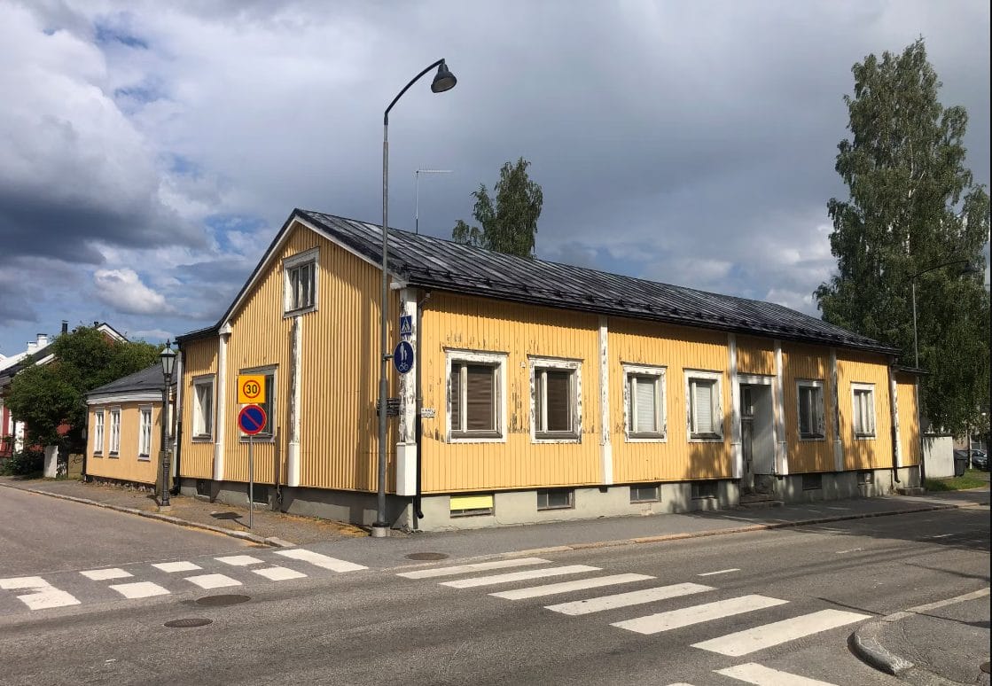 Keltaisen rakennuksen julkisivu risteyksessä