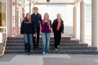Four pupils coming out of the high school.