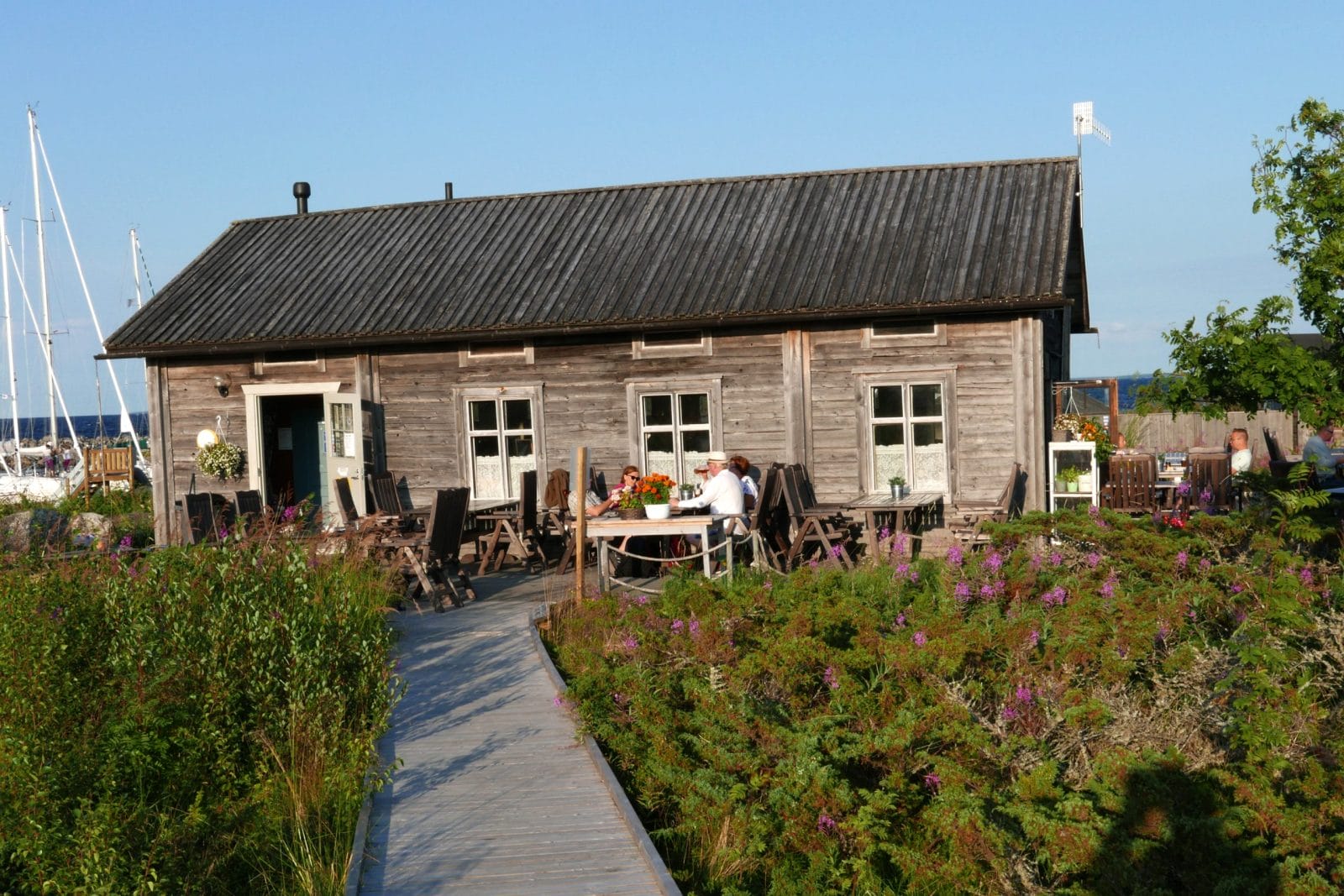 Kahvilarakennus, terassilla istuu ihmisiä.