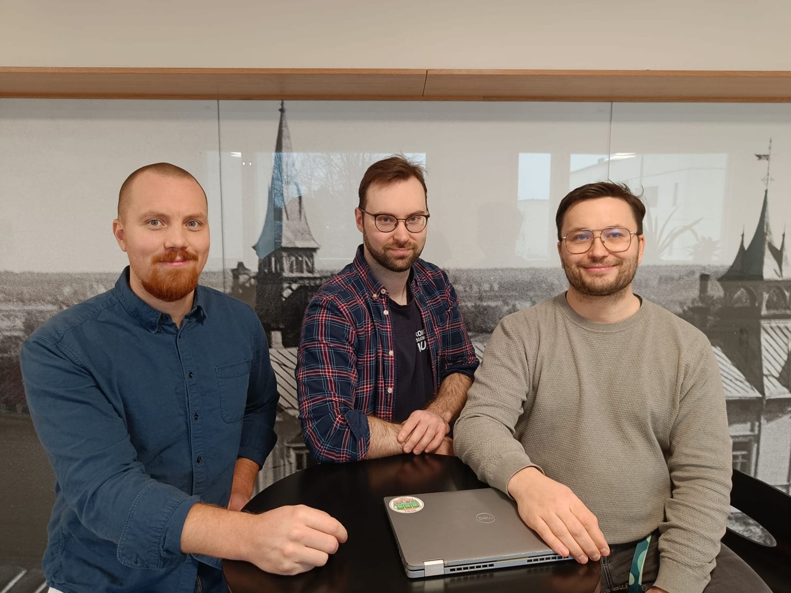 kolme henkilöä pöydän ääressä