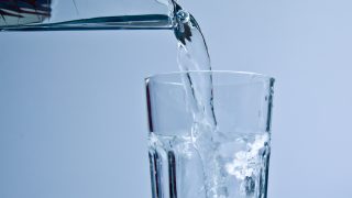 Vesihanasta valuu puhdasta vettä juomalasiin