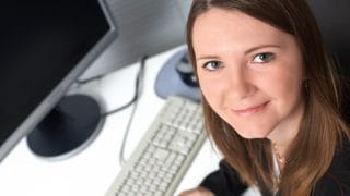 Nainen katsoo kuvaajaa, taustalla tietokone