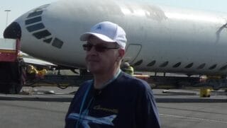 Mies seisoo lentokoneen edessä.