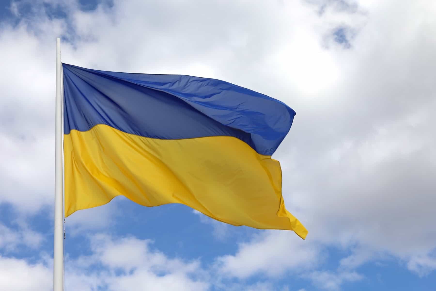 Ukrainan sinikeltainen lippu liehuu sinivalkoista taivasta vasten.